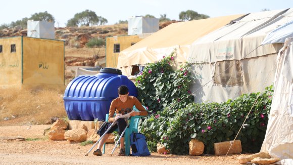 Saleh, niño de Siria leyendo en un campo de desplazados