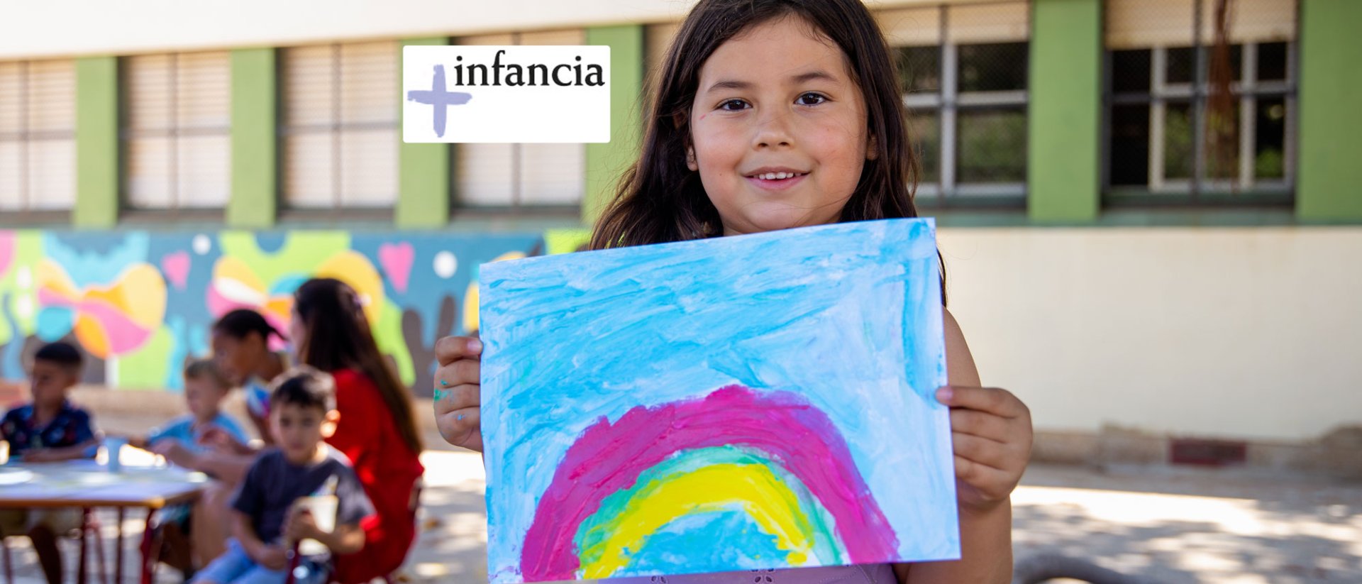 Proyecto + infancia - Una niña feliz con un dibujo en sus manos