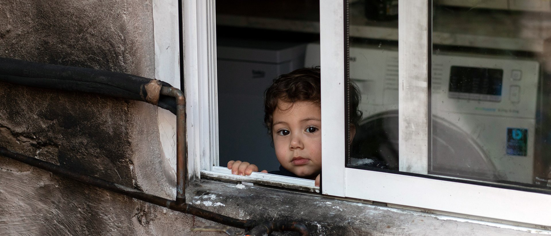 Informe pobreza Europa - Un niño mirando fuera de una ventana