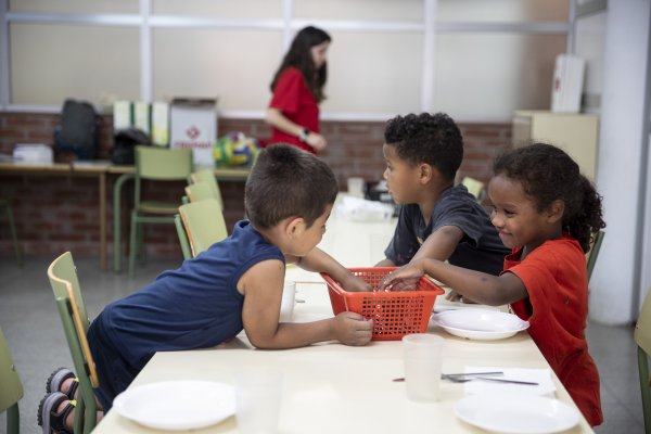 Els infants participants del casal parant taula per dinar. © Ferran Nadeu