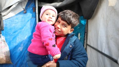 Bahjet, 12, y Raneem, 8 meses - Delante de la tienda de campaña en la que viven