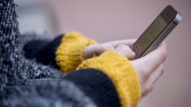 Consejos uso de las pantallas niños y niñas - En la foto: manos de un adolescente con el móvil